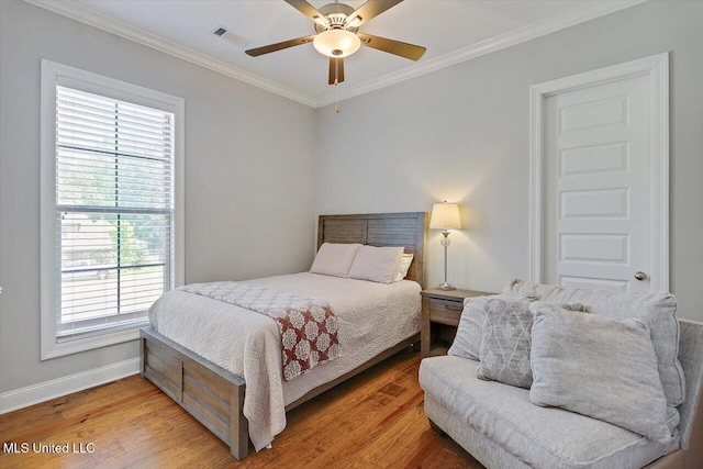 bedroom with baseboards, ornamental molding, visible vents, and multiple windows