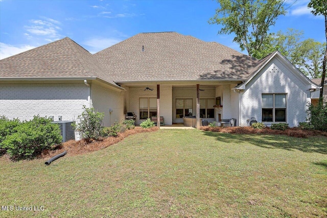 rear view of house with a lawn, a ceiling fan, and a shingled roof