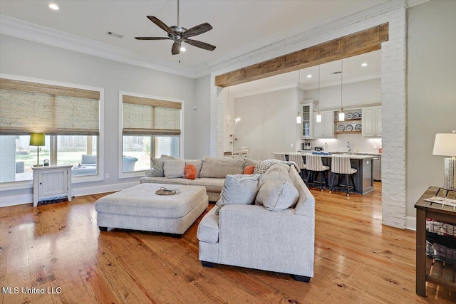 living area with ceiling fan, light wood-style flooring, recessed lighting, visible vents, and ornamental molding