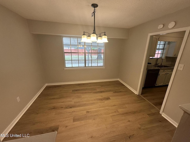 105 Poplar Dr, Brandon, MS 39047 - unfurnished dining area with a chandelier, dark wood finished floors, and a textured ceiling