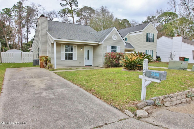 view of front of property with fence, a front yard, a shingled roof, central AC unit, and a chimney