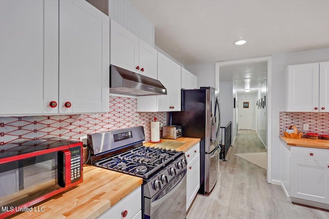 kitchen featuring white cabinets, exhaust hood, light wood-type flooring, butcher block counters, and stainless steel appliances