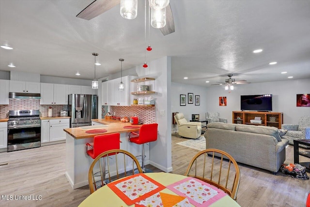 dining room with ceiling fan and light wood-type flooring