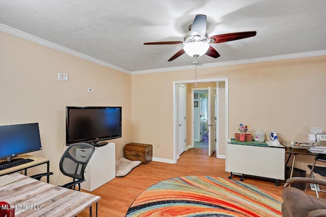 home office featuring ceiling fan, ornamental molding, a textured ceiling, and light wood-type flooring