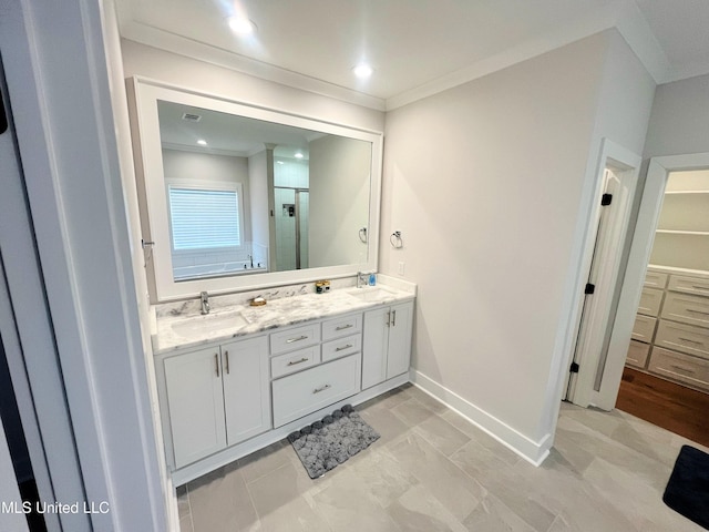 bathroom featuring vanity, a shower with door, and crown molding