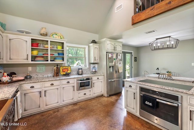kitchen with stainless steel appliances, concrete floors, a chandelier, and visible vents