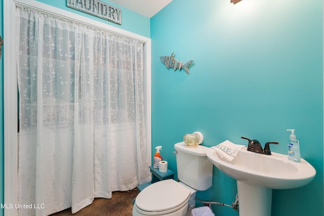 bathroom with toilet and a shower with curtain