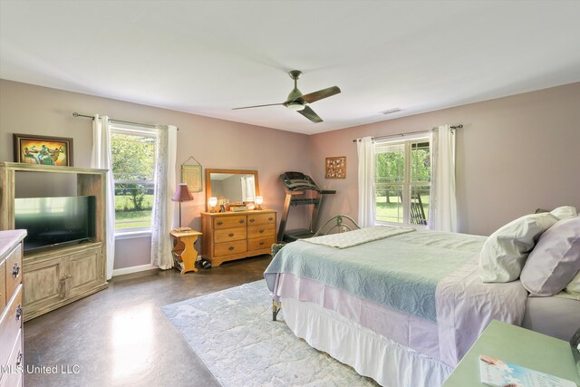 bedroom with multiple windows, concrete flooring, ceiling fan, and visible vents