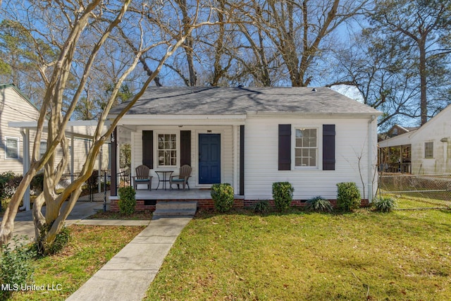 bungalow-style home with roof with shingles, covered porch, crawl space, fence, and a front lawn