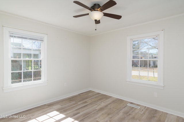 spare room with light wood-style flooring, baseboards, and crown molding