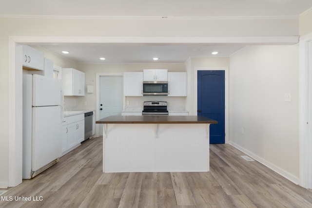 kitchen with light wood-style floors, white cabinetry, stainless steel appliances, and ornamental molding