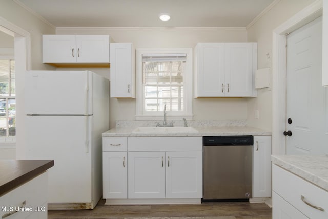 kitchen with crown molding, freestanding refrigerator, white cabinets, a sink, and dishwasher