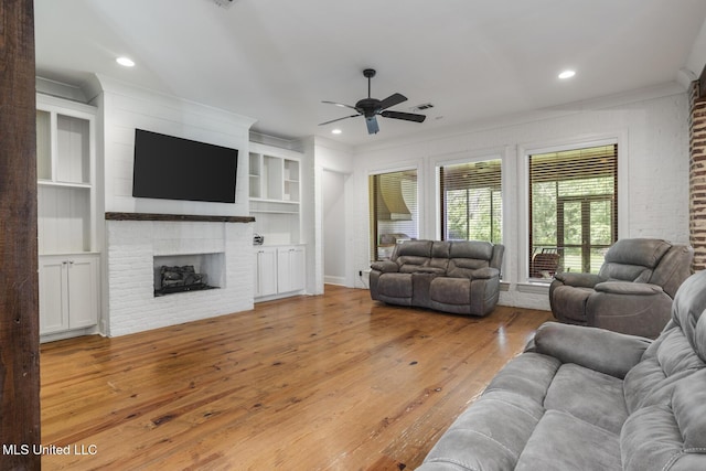 123 Klaas Blvd, Madison, MS 39110 - living area featuring a ceiling fan, light wood-style flooring, a brick fireplace, recessed lighting, and ornamental molding