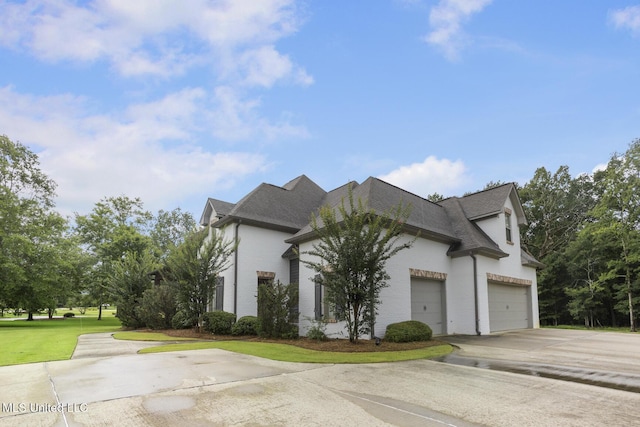 123 Klaas Blvd, Madison, MS 39110 - view of home's exterior with concrete driveway, a shingled roof, an attached garage, brick siding, and a lawn