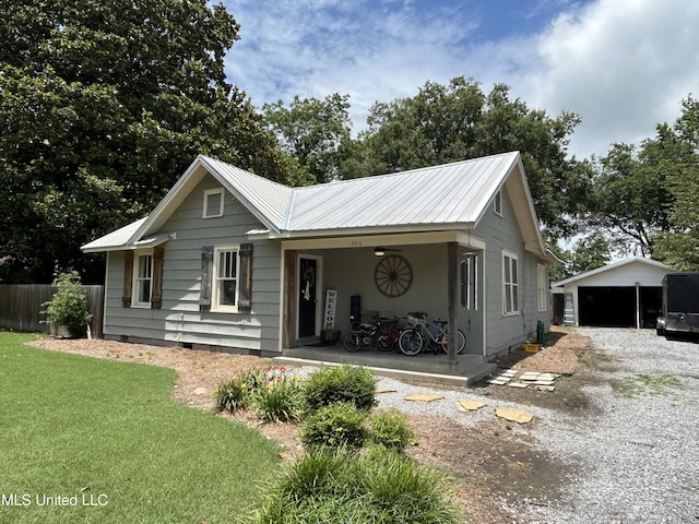 1006 Lamar St, Cleveland, MS 38732 - view of front facade with an outdoor structure, metal roof, crawl space, and gravel driveway