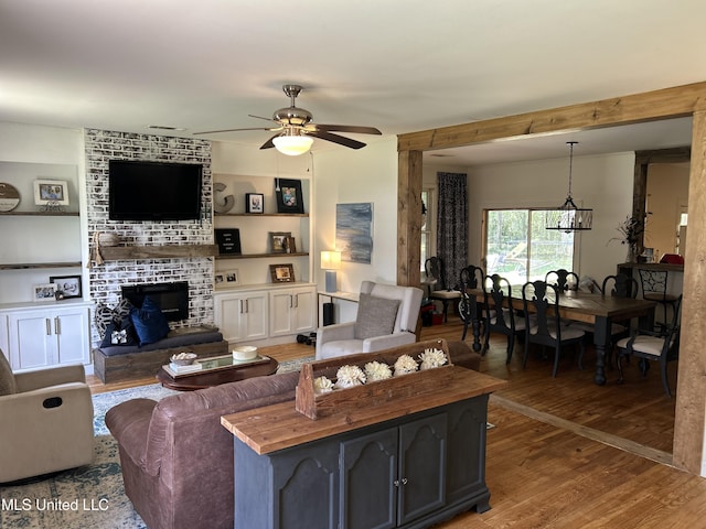1006 Lamar St, Cleveland, MS 38732 - living area with wood finished floors, a ceiling fan, and a brick fireplace