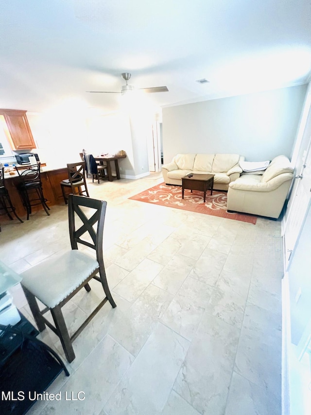 living area with visible vents and ceiling fan