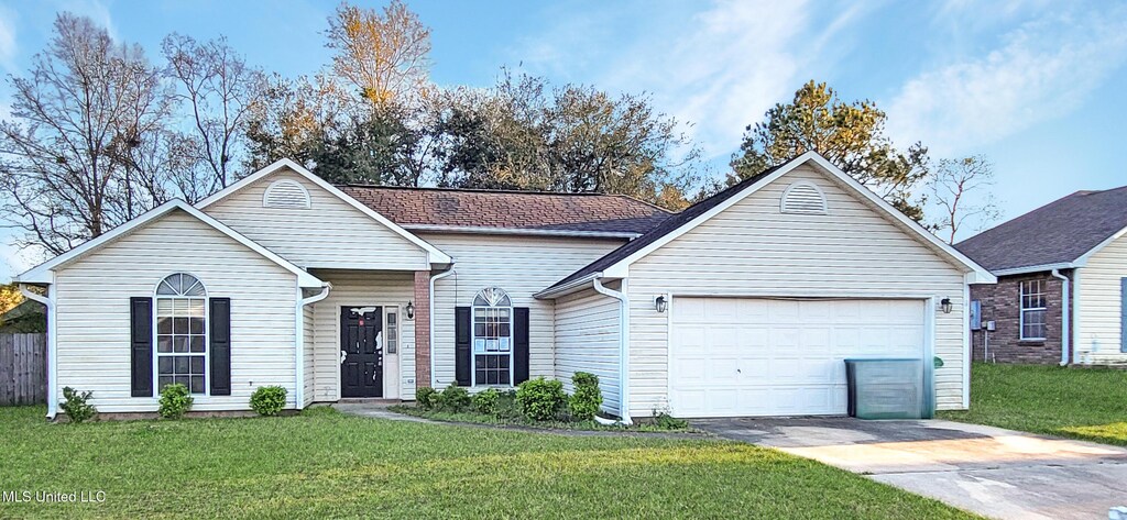 15031 Sagewood St, Gulfport, MS 39503 - ranch-style house with an attached garage, concrete driveway, and a front lawn