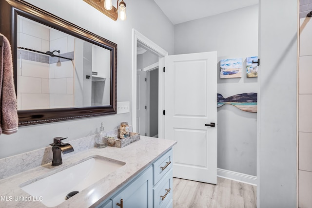 bathroom with vanity, wood-type flooring, and tiled shower