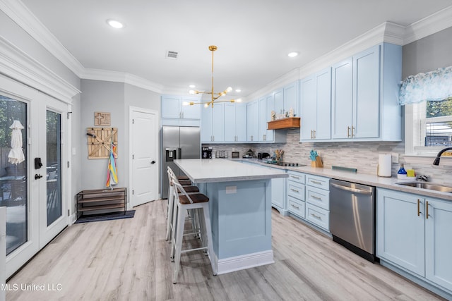 kitchen featuring pendant lighting, sink, appliances with stainless steel finishes, tasteful backsplash, and a kitchen island