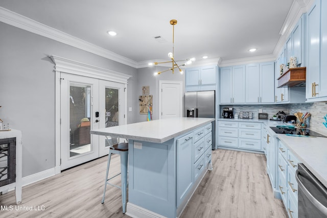 kitchen with crown molding, hanging light fixtures, stainless steel appliances, a center island, and tasteful backsplash