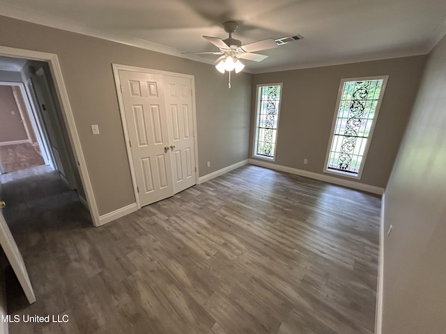 215 Quail Trl, Greenwood, MS 38930 - unfurnished bedroom featuring wood finished floors, baseboards, crown molding, ceiling fan, and a closet