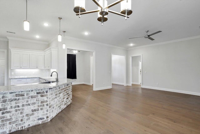 kitchen with white cabinetry, light stone counters, wood-type flooring, and sink