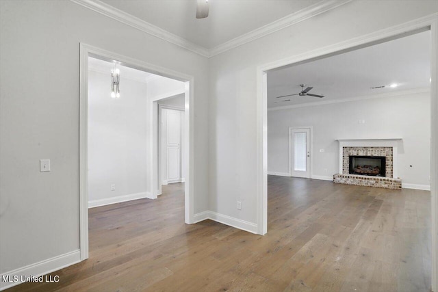 unfurnished living room featuring crown molding, wood-type flooring, and ceiling fan