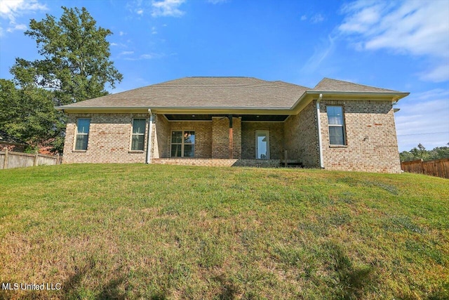 rear view of house featuring a yard