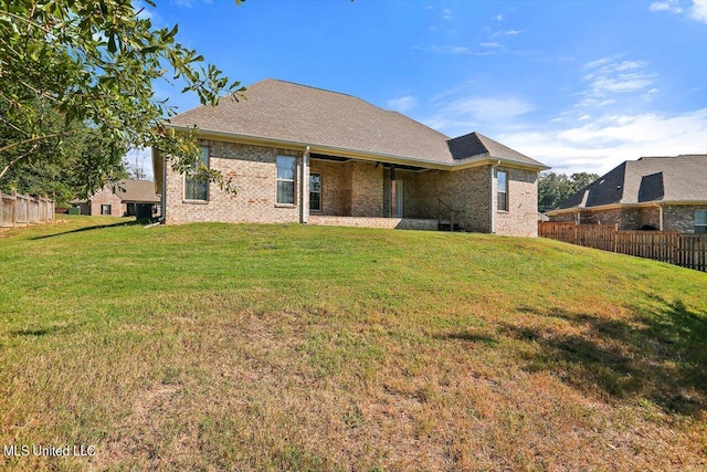 back of property featuring a lawn