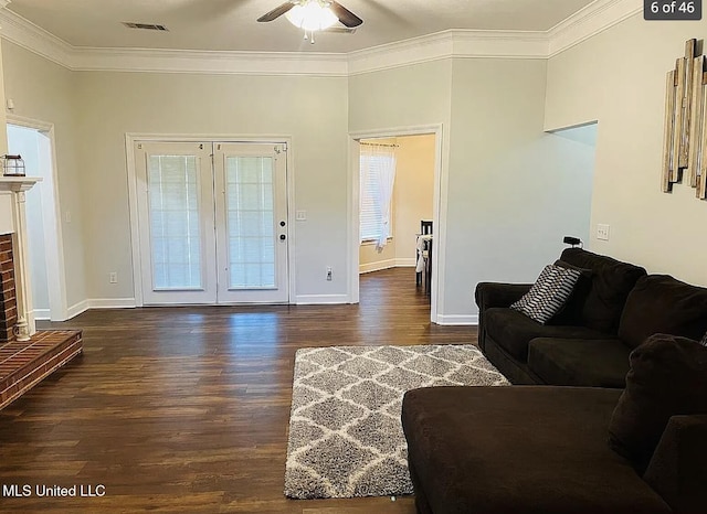 living room with a fireplace, ceiling fan, crown molding, and dark hardwood / wood-style flooring