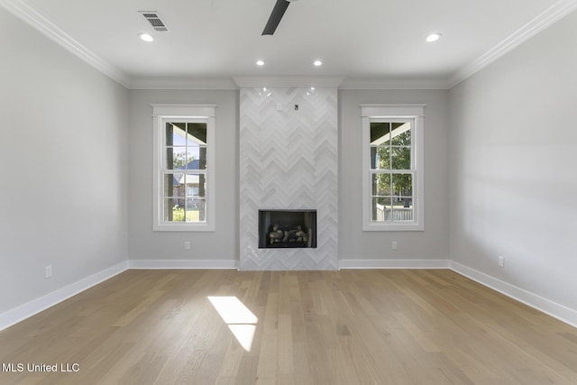 111 Grand Oak Blvd, Clinton, MS 39056 - unfurnished living room with plenty of natural light, light wood finished floors, a fireplace, baseboards, and crown molding