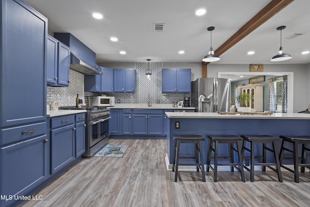 56 53rd St, Gulfport, MS 39507 - kitchen with stainless steel appliances, blue cabinets, a breakfast bar area, tasteful backsplash, and recessed lighting