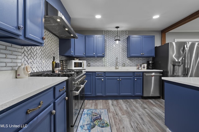 56 53rd St, Gulfport, MS 39507 - kitchen featuring stainless steel appliances, extractor fan, blue cabinetry, backsplash, and recessed lighting