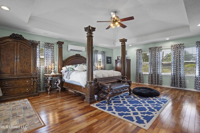 56 53rd St, Gulfport, MS 39507 - bedroom featuring a raised ceiling, an AC wall unit, a textured ceiling, light wood-type flooring, and recessed lighting