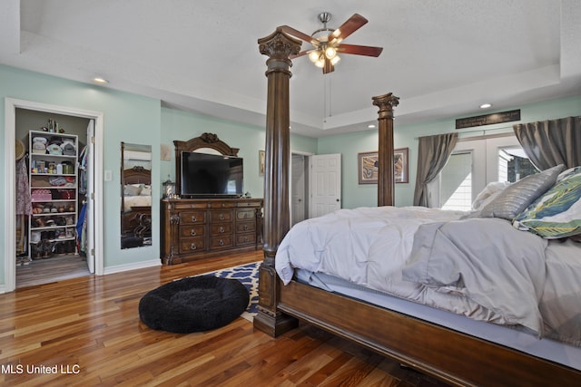 56 53rd St, Gulfport, MS 39507 - bedroom featuring a tray ceiling, decorative columns, wood finished floors, recessed lighting, and a spacious closet