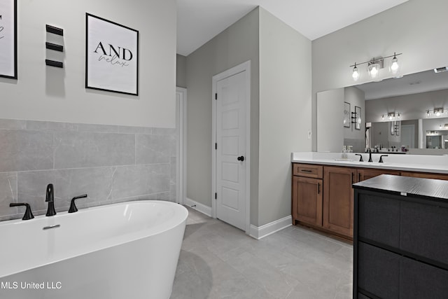 full bathroom with a freestanding bath, visible vents, vanity, and baseboards