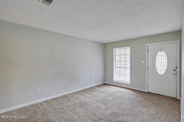 entryway featuring carpet, visible vents, a textured ceiling, and baseboards