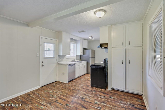 kitchen featuring dark wood-style flooring, appliances with stainless steel finishes, white cabinetry, a sink, and wall chimney exhaust hood