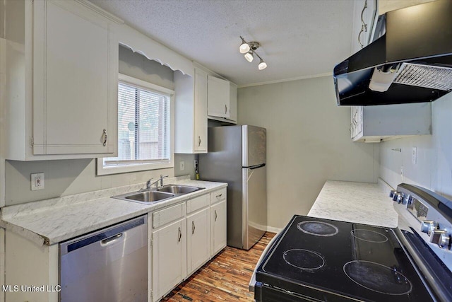 kitchen with stainless steel appliances, light countertops, a sink, a textured ceiling, and under cabinet range hood