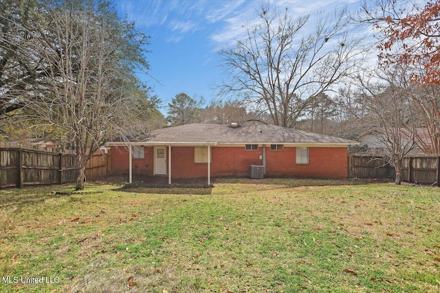 back of house with brick siding, a fenced backyard, and a yard