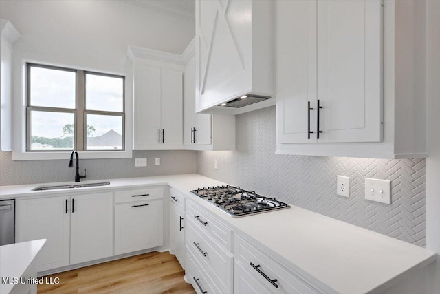 420 Lennon Ln, Brandon, MS 39047 - kitchen with stainless steel gas cooktop, light countertops, custom range hood, a sink, and backsplash