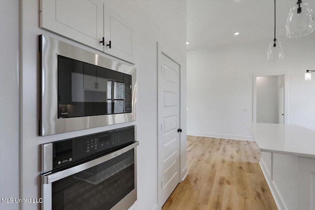 420 Lennon Ln, Brandon, MS 39047 - kitchen featuring light wood-style floors, light countertops, stainless steel appliances, white cabinetry, and pendant lighting