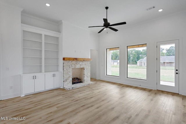 420 Lennon Ln, Brandon, MS 39047 - unfurnished living room with visible vents, a brick fireplace, crown molding, and light wood-type flooring