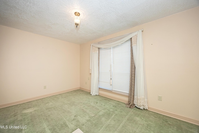 spare room with carpet and a textured ceiling