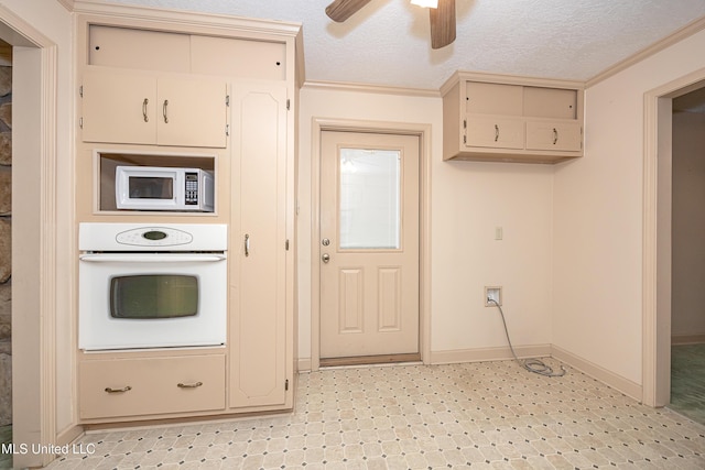 kitchen featuring ceiling fan, cream cabinets, a textured ceiling, white appliances, and ornamental molding