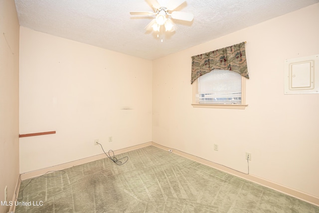 carpeted empty room featuring a textured ceiling, electric panel, and ceiling fan