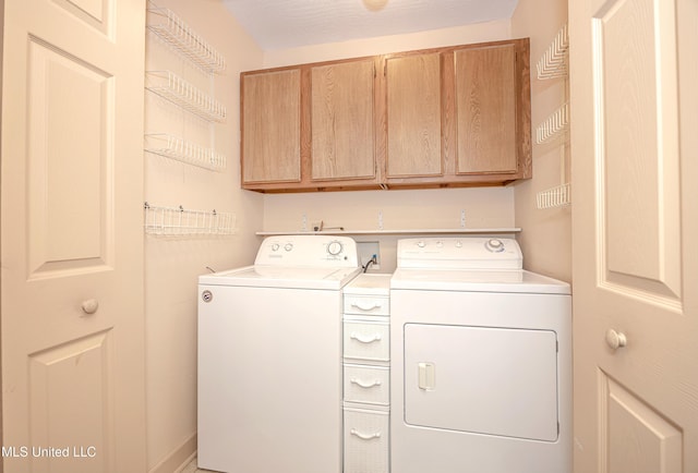 laundry room featuring cabinets and washing machine and clothes dryer