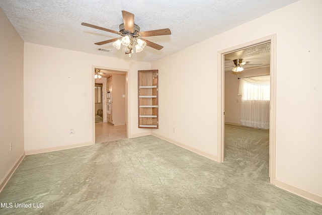 spare room with light carpet and a textured ceiling