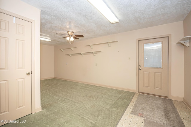 unfurnished room with ceiling fan and a textured ceiling